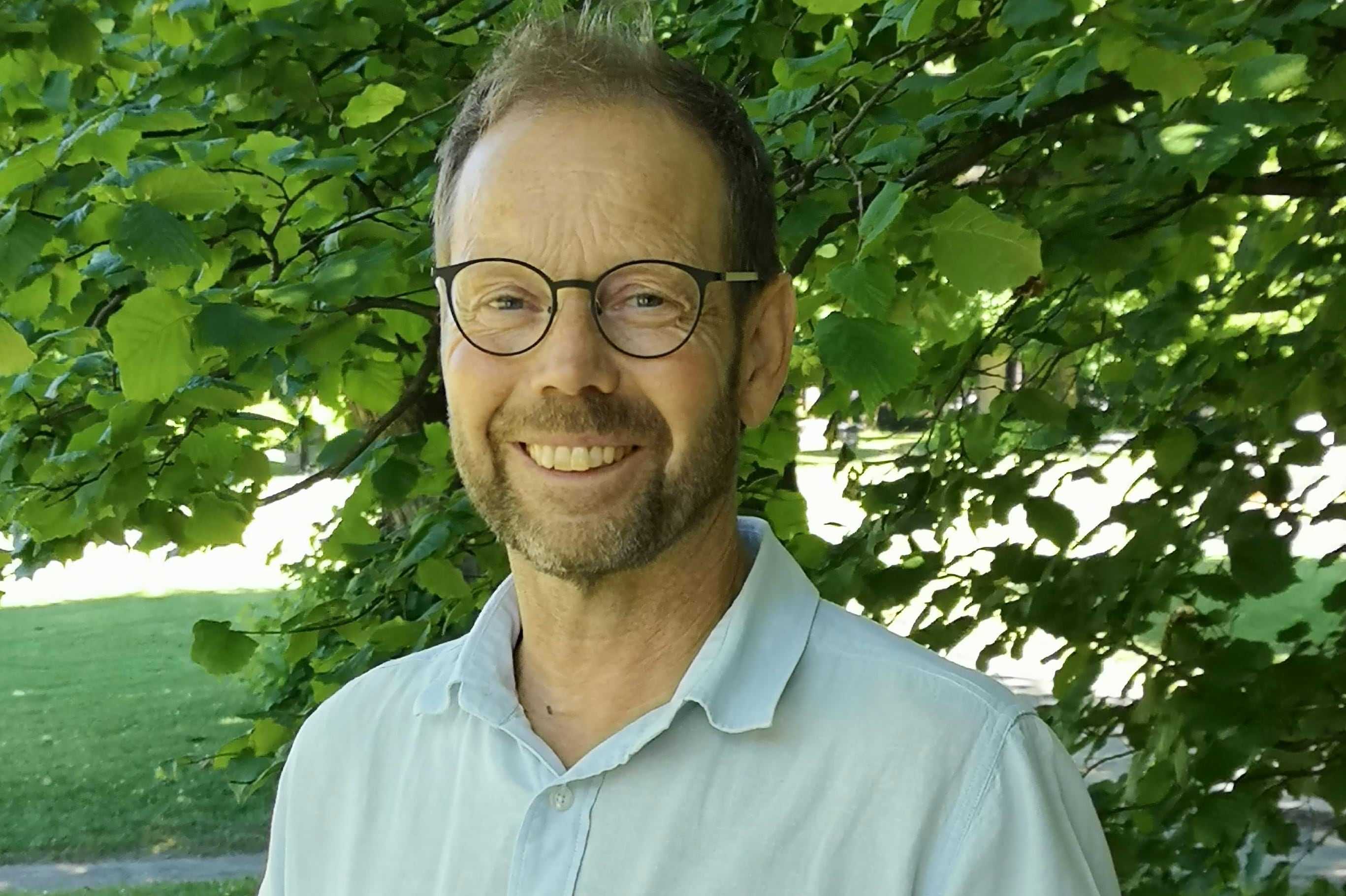 Portrett av ansatt Bjørnar Bjelland, med trær i bakgrunn.